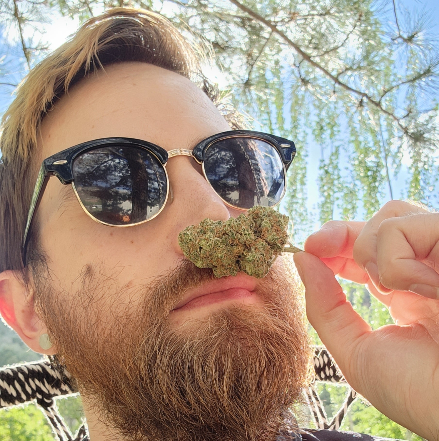 man with sunglasses and a bread smelling marijuana