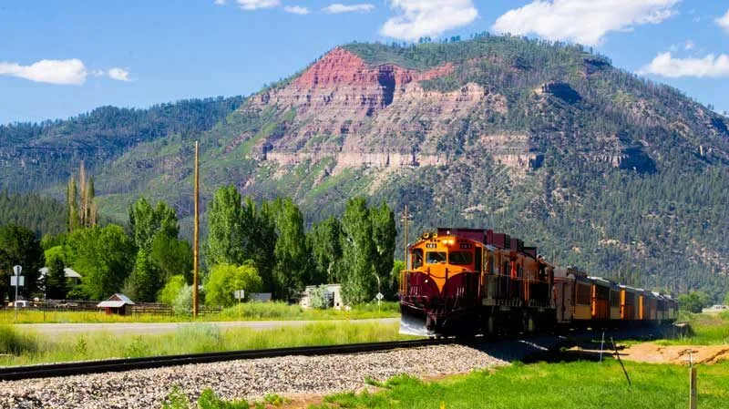 | Durango Rec Room marijuana dispensary durango co - A Durango and Silverton Klondike Diesel double header passenger train enters Durango, Colorado, with trees and mountains in the background