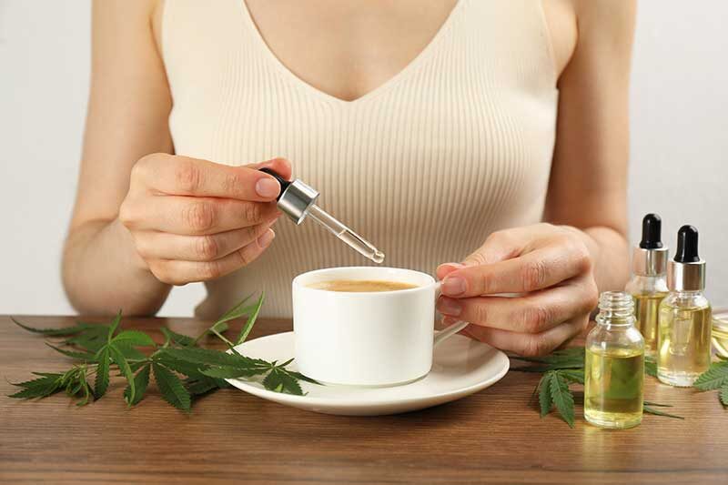 | Durango Rec Room what are the effects of cbd - Woman dripping THC tincture or CBD oil into coffee at wooden table, closeup